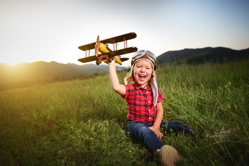 Wall Mural - happy child dreams of traveling and playing with an airplane pil