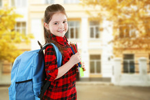 Little Girl With Blue Back Pack Holding Pencils On Blurred School Building Background