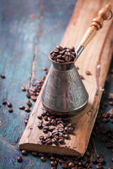 Wall Mural - Roasted coffee beans in a cooper turk on a vintage background, copy space