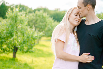 Wall Mural - Couple standing in park and hugging