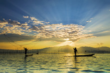 Silhouettes Of The Traditional Fishermen Throwing Fishing Net During Sunrise, Thailand