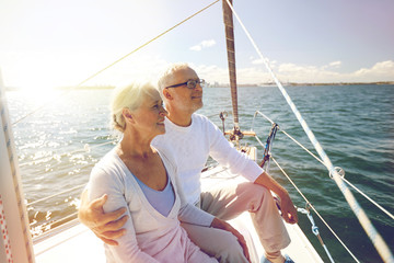 Canvas Print - senior couple hugging on sail boat or yacht in sea