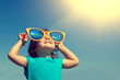 canvas print picture - Happy little girl with big sunglasses looking at the sun