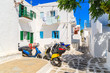 MYKONOS TOWN, GREECE - MAY 16, 2016:  Colorful scooters parked on street in Mykonos town on island of Mykonos, Cyclades, Greece