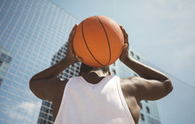 Young Man Holding Basketball Behind His Head