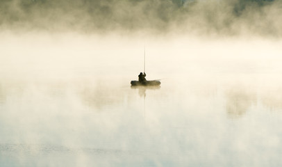 The fisherman by the boat in fog