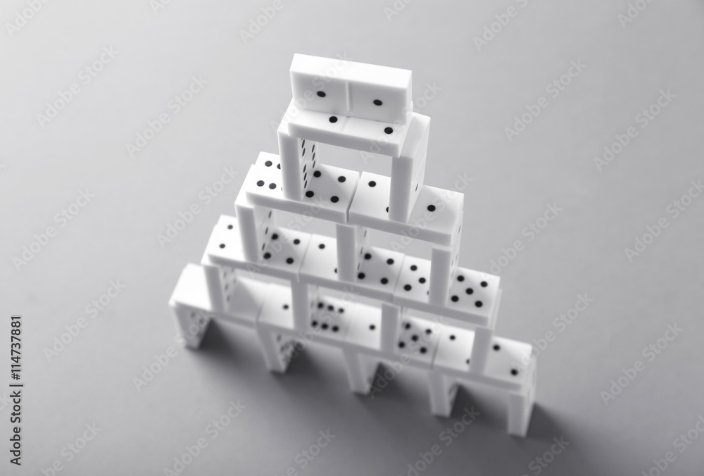 Tower of dominoes on grey background