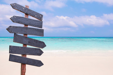 Wood signs on the beach. Sea and blue sky background