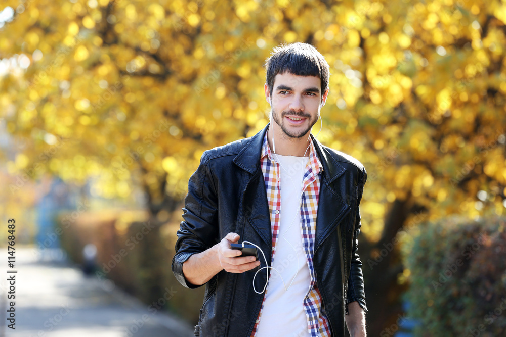 Young man in a park listening to music