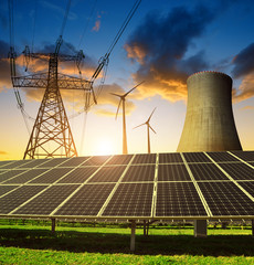 solar panels in the background nuclear power plant, wind turbines and electricity pylon at sunset. c