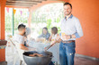 © AntonioDiaz - Attractive guy cooking hamburgers at a barbecue