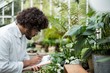 © WavebreakmediaMicro - Male scientist writing in clipboard while examining plants
