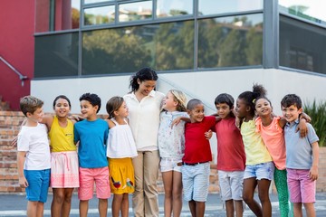 Wall Mural - Teacher with children standing outside school