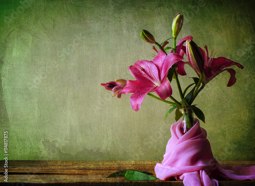 Fotografía Still life with pink lilies flower and silky scarf on a rustic wooden table