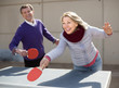 © caftor - Happy mature man and a woman playing table tennis