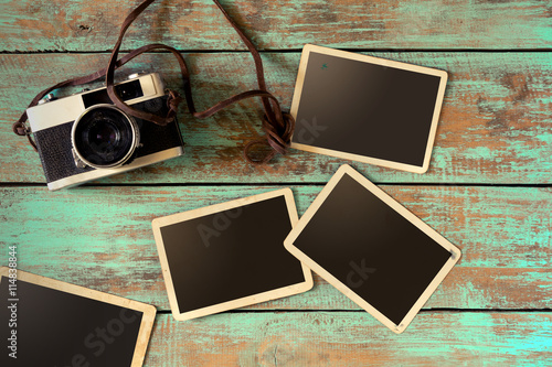 Fotografie, Obraz Retro camera and empty old instant paper photo album on wood table - blank photo