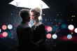 Beautiful couple man with woman with white umbrella in flash lights and rain drops
