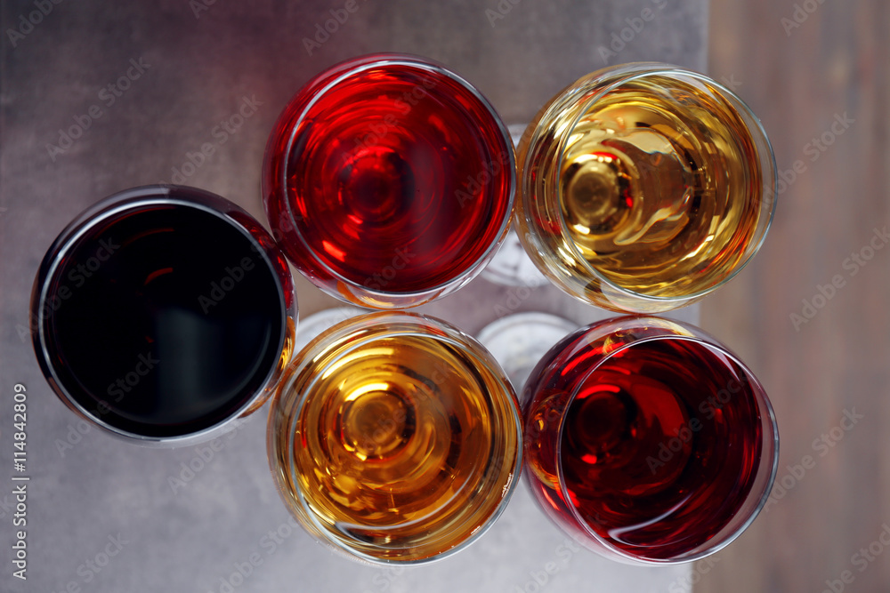 Glasses with wines of different colors on a wooden table