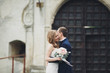 © olegparylyak - Happy wedding couple hugging and smiling each other on background old castle