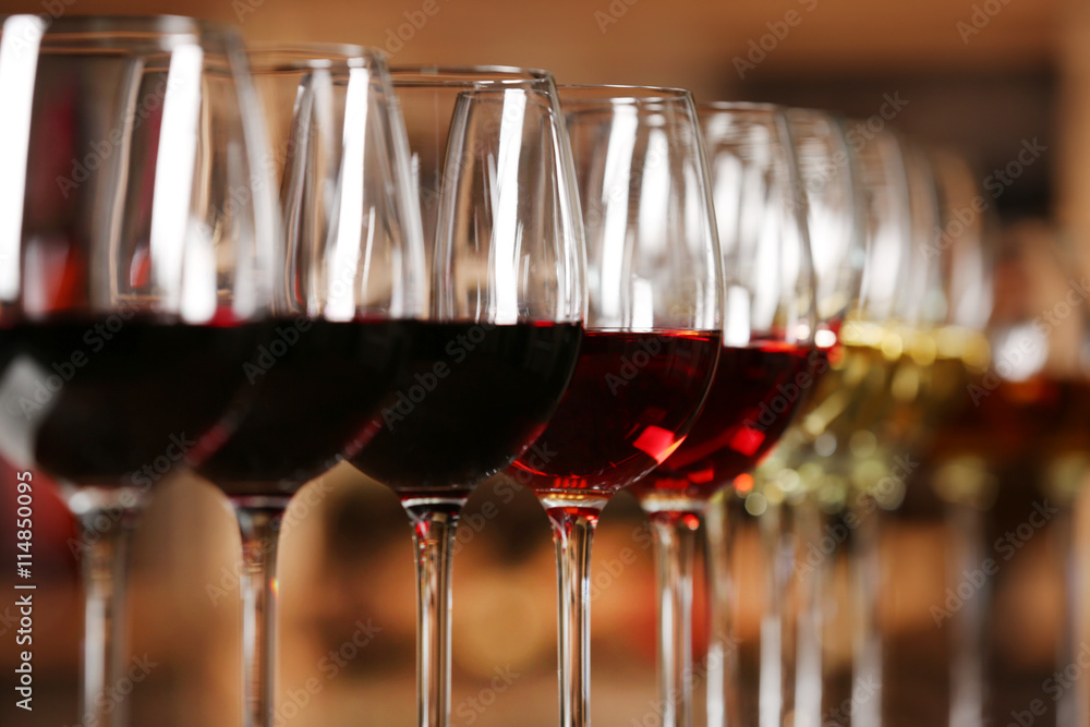 Many glasses of different wine in a row on bar counter