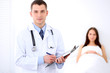 © rogerphoto - Friendly male doctor on the background with his patient in the bed