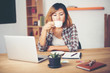 © Johnstocker - Young business woman sitting in office desk with cup of coffee r