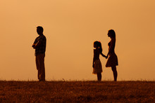 Silhouette Of A Angry Husband  Turning Back While His Wife And Daughter Are Looking At Him.
