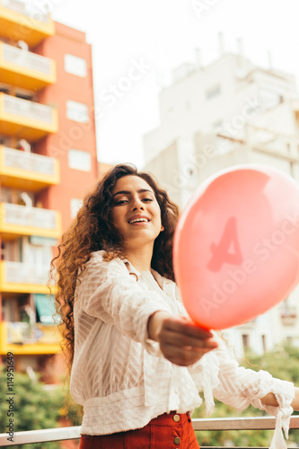 Fotografía Young and beautiful woman playing outdoors with a red balloon