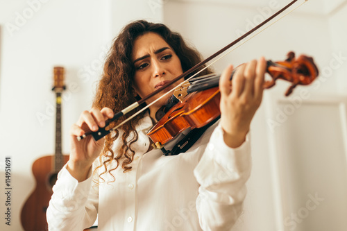 Obrazy filharmonia  dziewczyna-gra-na-skrzypcach-mloda-kobieta-samotnie-studiujaca-muzyke-w-domu-w-salonie-z-naturalnym