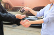 © jayzynism - Business hand giving a key of buyer at rental car.