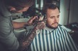 © Nejron Photo - Confident man visiting hairstylist in barber shop.