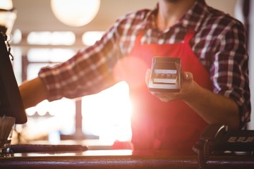 Mid section of waiter showing credit card machine 