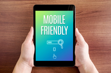 Wall Mural - two hand holding tablet with mobile friendly and icon on screen