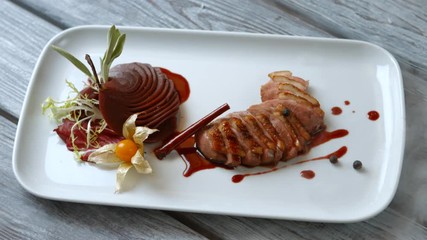 Wall Mural - Pieces of meat with herbs. Cooked pear and meat. Duck breast and frisee lettuce. Tasty dish with decoration.