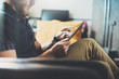 © SFIO CRACHO - Successful Trade Manager reading business news modern Interior Design Loft Office.Man relaxing Vintage Sofa,Use contemporary tablet,sharing information.Blurred Background.New Startup Idea Process.