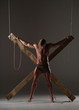 © kazanovskyiphoto - Sexual naked man, muscular, hands tied rope to wooden beams