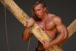 © kazanovskyiphoto - Men with perfect muscular naked torso, holding hands wooden beams