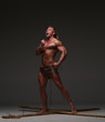 © kazanovskyiphoto - Screaming naked muscular man, hands tied rope to wooden beams