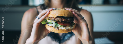 Fotomural Young girl holding in female hands fast food burger, american unhealthy calories