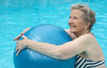 Active senior woman in the pool, doing exercises