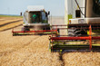 © oticki - Combine harvester in action on wheat field