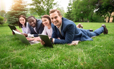 Sticker - Joyful colleagues sitting on the grass