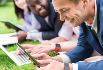 Sticker - Cheerful colleagues sitting on the grass