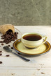 Чашка черного кофе и кофейные зерна на деревянном фоне.