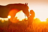 Fototapeta Konie - Beautiful silhuette of girl and horse at sunset 