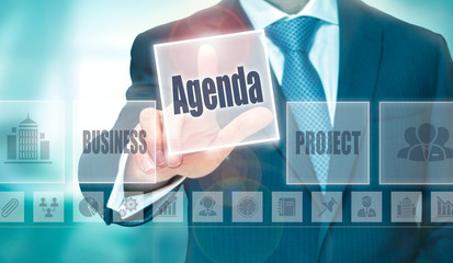 Wall Mural - A businessman selecting a Agenda Concept button on a clear screen.