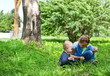 © AlexandraBudzinskaya - baby boy and little girl sitting playing on grass in park