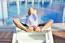 Woman In White Hat Lying On A Lounger Near The Swimming Pool. Su