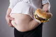 Fat women suffer from obesity with big hamburger in hand, junk food concept
