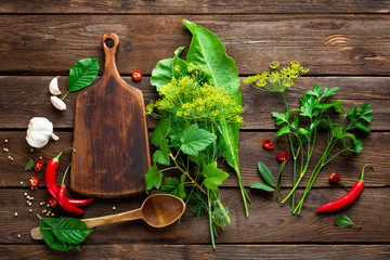 Canvas Print - dark culinary background with various herbs and spices, top view, rustic style